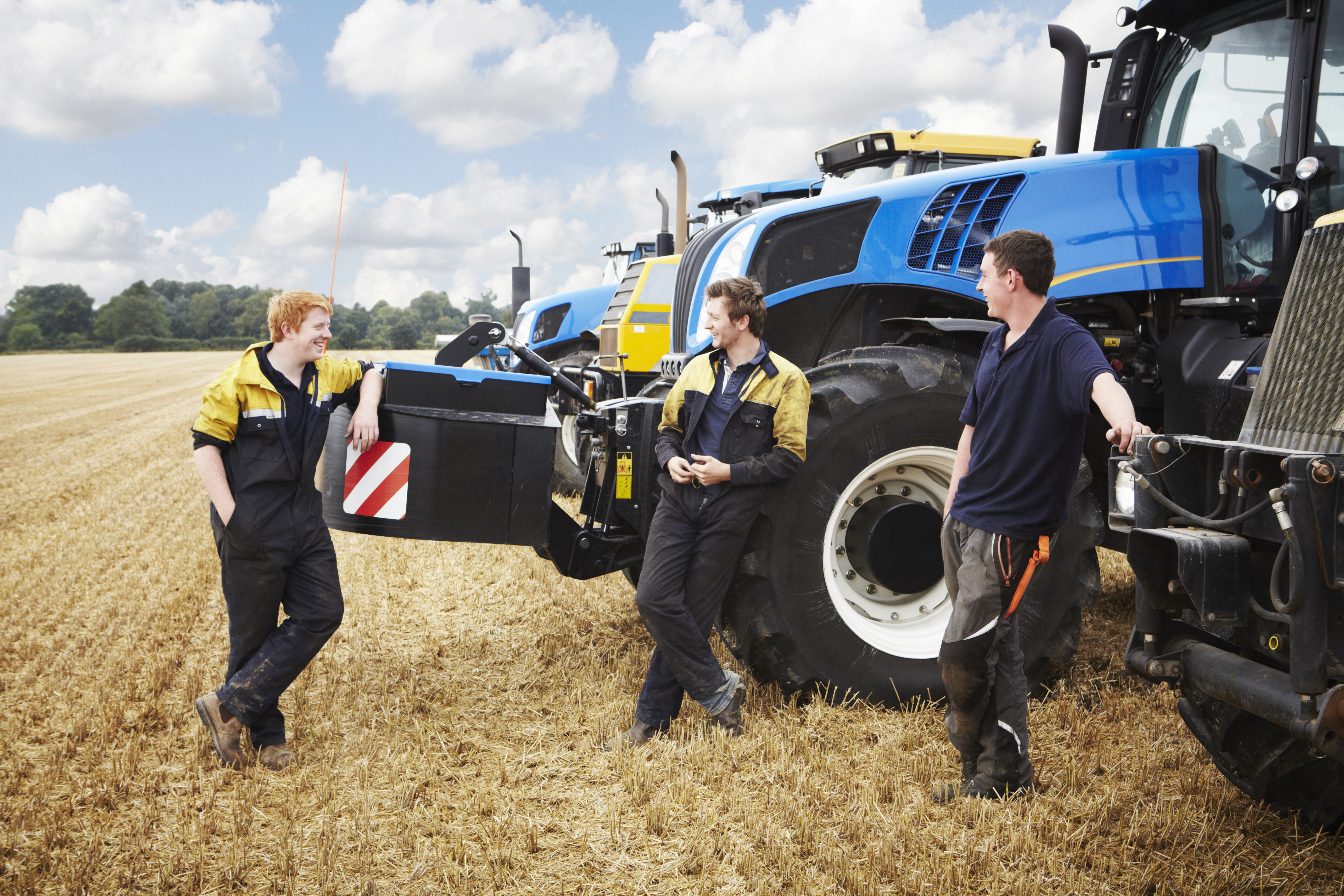 A group of men standing next to a tractor